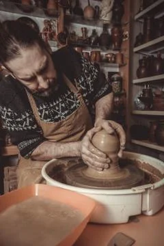 Elderly man making pot using pottery wheel in studio Stock Photos