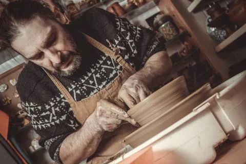 Elderly man making pot using pottery wheel in studio Stock Photos
