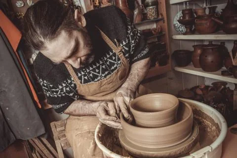 Elderly man making pot using pottery wheel in studio Foto stock