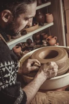 Elderly man making pot using pottery wheel in studio Stock Photos