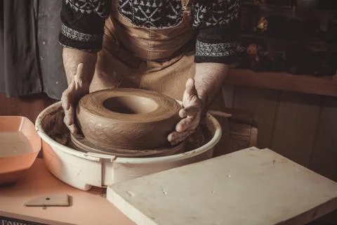 Elderly man making pot using pottery wheel in studio Stock Photos