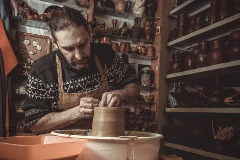 Elderly man making pot using pottery wheel in studio Stock Photos
