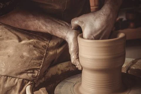 Elderly man making pot using pottery wheel in studio Stock Photos