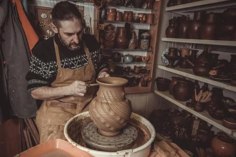 Elderly man making pot using pottery wheel in studio Stock Photos