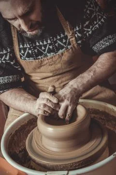 Elderly man making pot using pottery wheel in studio Stock Photos
