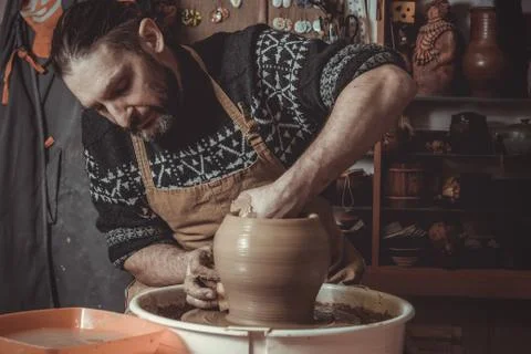 Elderly man making pot using pottery wheel in studio Stock Photos