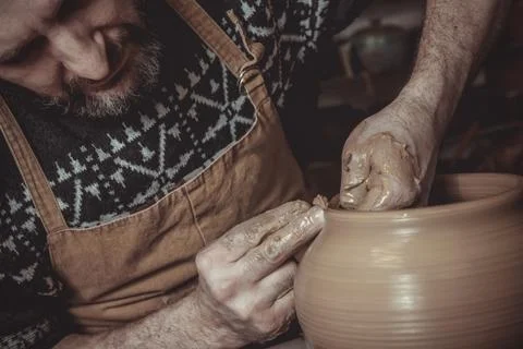 Elderly man making pot using pottery wheel in studio Stock Photos