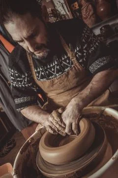 Elderly man making pot using pottery wheel in studio Stock Photos
