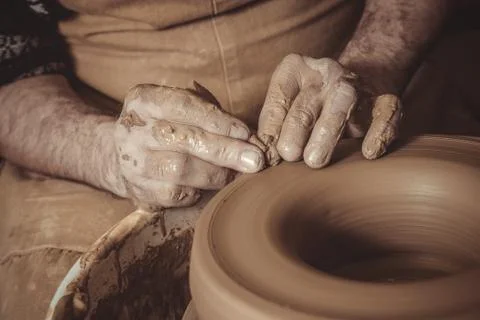 Elderly man making pot using pottery wheel in studio Stock Photos