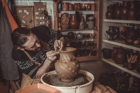Elderly man making pot using pottery wheel in studio Stock Photos
