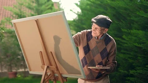 Elderly man painting on a canvas Vidéo 80990911