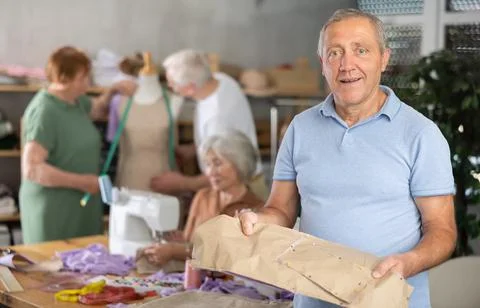 Elderly man with pattern at sewing master class Stock Photos