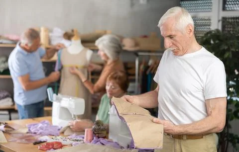 Elderly man with pattern at sewing master class 스톡 사진