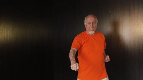 An elderly man performs hand blocks Stock Footage 312096835