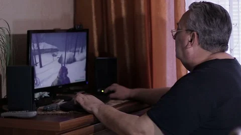 Elderly man playing online computer game Stock Footage 72743272
