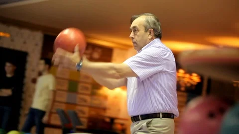 Elderly man plays bowling Stock Footage 100243101