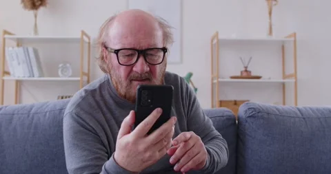 Elderly Man With Poor Eyesight Using Phone At Home Stock Footage 335762461