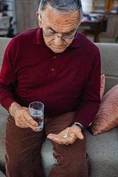 Elderly man preparing to take medication with water Stock Photos