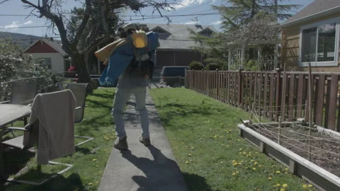 Elderly man putting a dog into a backpack carrier and walking away Stock Footage 331658097
