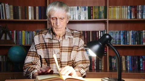 Elderly man reading book in library Stock Footage 167599269
