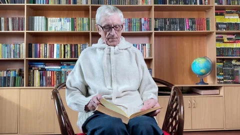 Elderly man reading book in library Stock Footage 170212039
