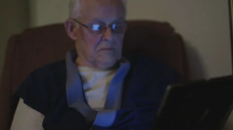 Elderly man reading on iPad tablet Stock Footage 37345201