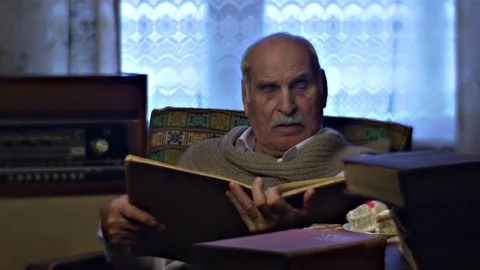 Elderly Man is Reading at Lunch Cake Pieces Grandfather in Cosy Soviet Style Stock Footage 72229400