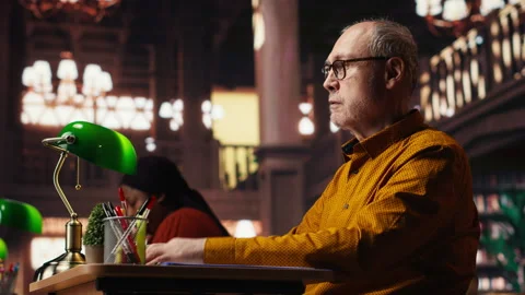 Elderly man with a respiratory problem having a panic attack in the library Stock Footage 313304024
