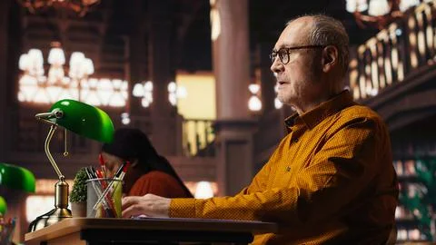 Elderly man with a respiratory problem having a panic attack in the library Foto stock