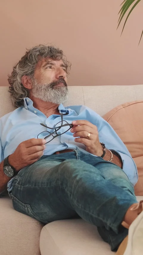 An elderly man is resting lying on the sofa in cozy living-room Stock Footage 254913357