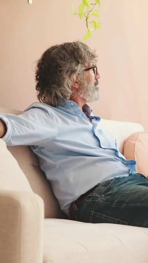 An elderly man is resting while sitting in cozy living-room Stock Footage 252207355