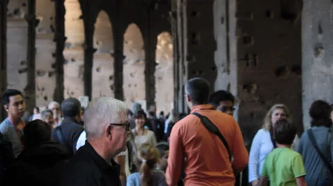 An elderly man rests while watching tourists walk in roman colosseum Stock Footage 36778269