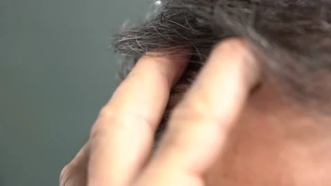 An elderly man runs his hand through his gray hair 스톡 동영상 166104109