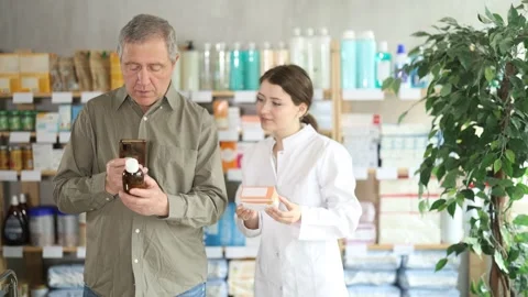 Elderly man scans QR code on box cough syrup label. Female pharmacist offers Stock Footage 341381715