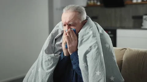 An elderly man is sick at home with a temperature. The pensioner has a cold or Stock Footage 236400796