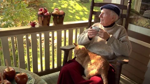 Elderly man sitting on balcony drinking apple punch 스톡 동영상 8572989