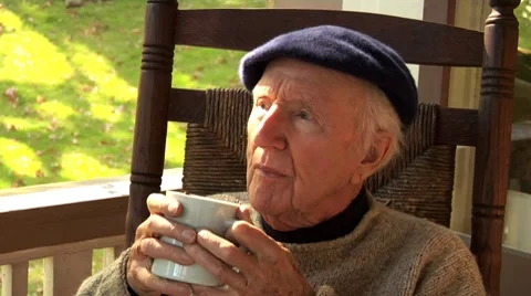 Elderly man sitting on balcony drinking apple punch Stock Footage 8573350