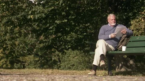 An elderly man sitting on a bench Stock Footage 11330405