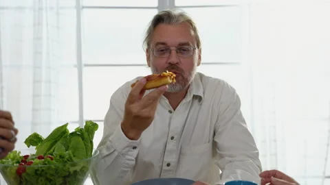 Elderly man sitting on the dining table relishing pizza. Stock Footage 236667023