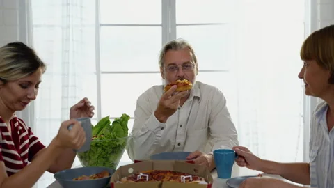Elderly man sitting on the dining table relishing pizza. healthy food concept Stock Footage 236876247