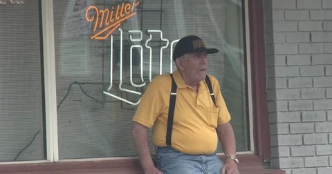 Elderly Man Sitting in Front of Bar Smoking Stock Footage 76920772