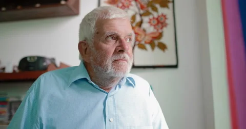 An elderly man sitting by the window Stock Footage 105168824