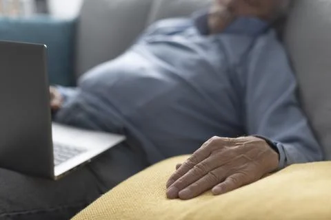 Elderly man sleeping on the couch Stock Photos