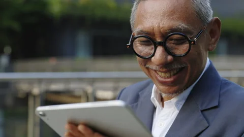 Elderly Man Smiling While Using Tablet Outdoors Stock Footage 280998807