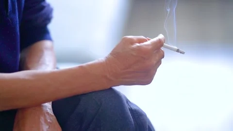 Elderly Man Smoking as Burning Cigarette Ember Glows in Close-Up Stock Footage 341917020