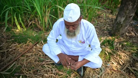 Elderly Man Smoking While Sitting on Farmland Stock Footage 290121177