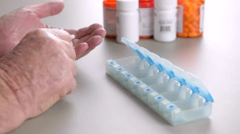 Elderly man sorting pills into daily pill box. 스톡 동영상 58882760