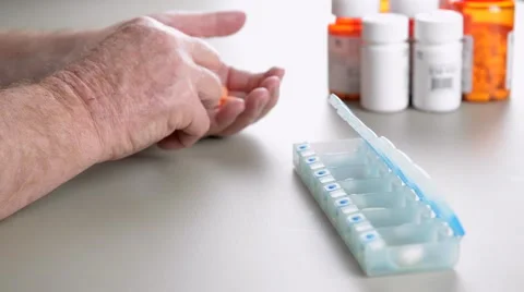 Elderly man sorting pills into daily pill box. Stock Footage 58882764