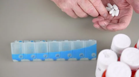 Elderly man sorting pills into daily pill box. Stock Footage 58882785