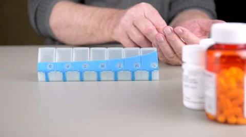 Elderly man sorting pills into daily pill box. Stock Footage 58882789